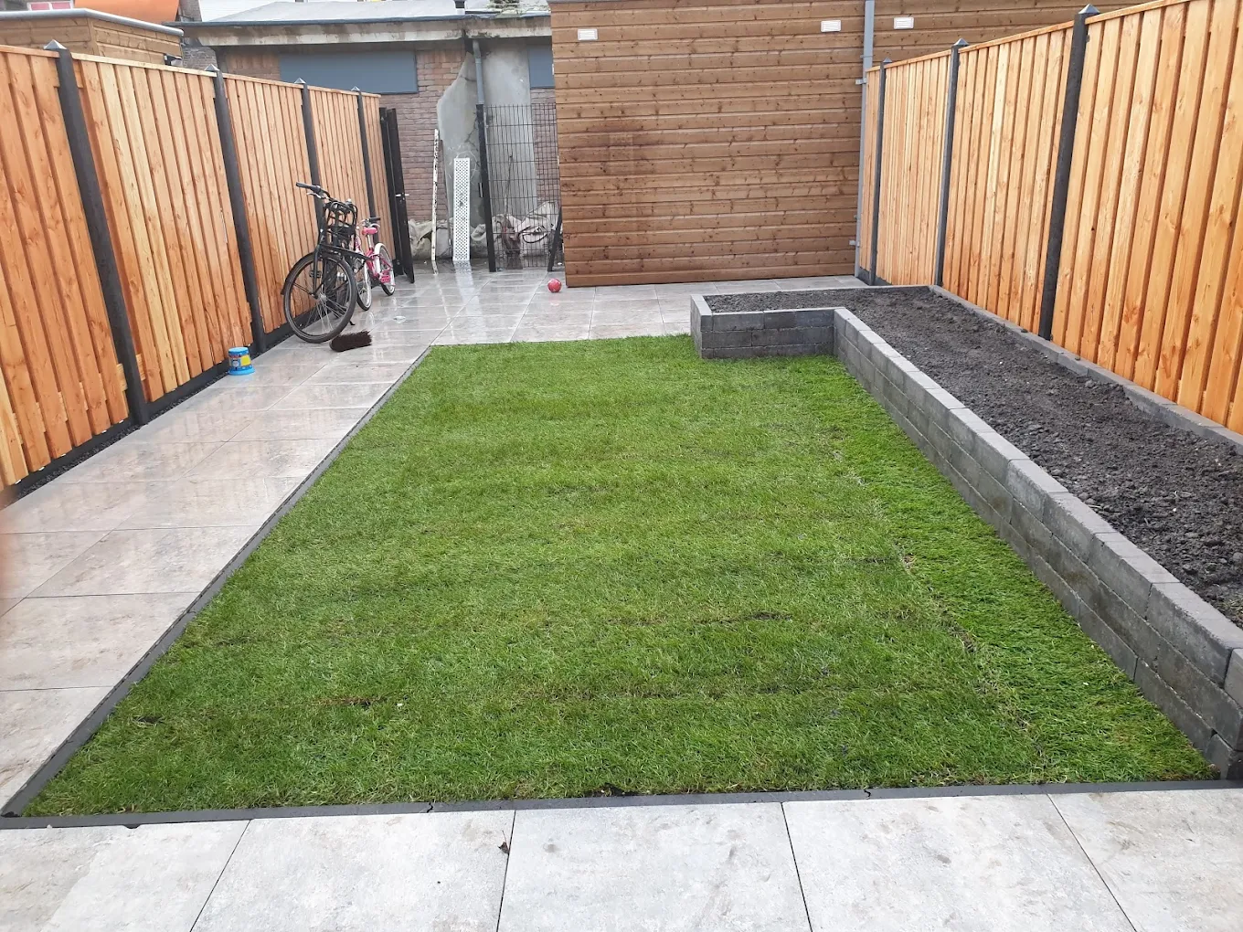 Nieuwe houten schutting met strakke bestrating